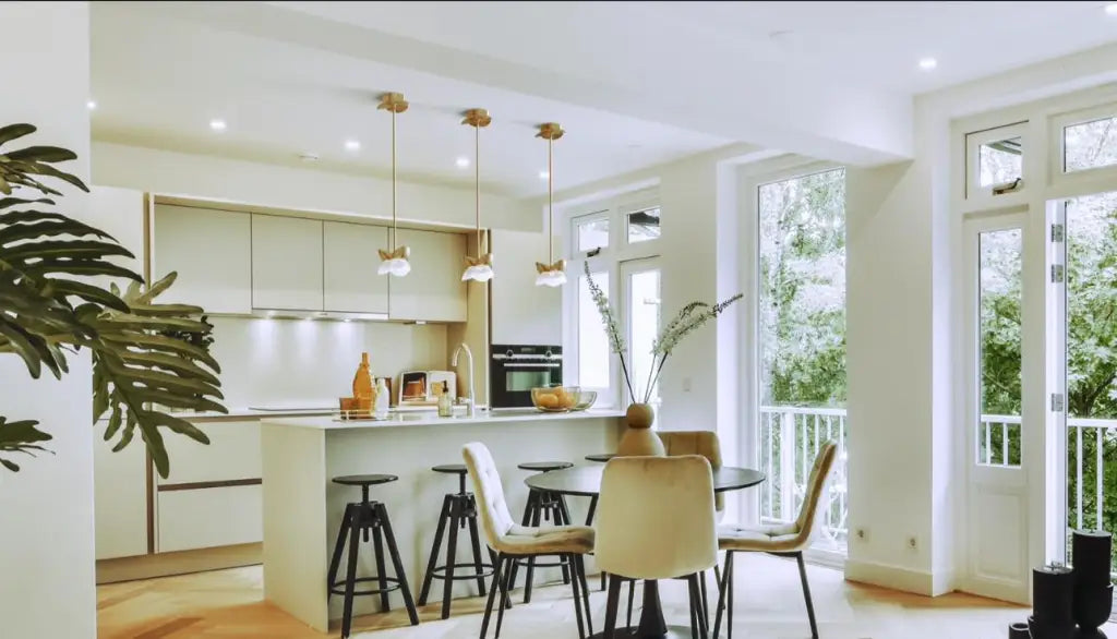 Modern kitchen with white cabinets, a dining area, and large windows.