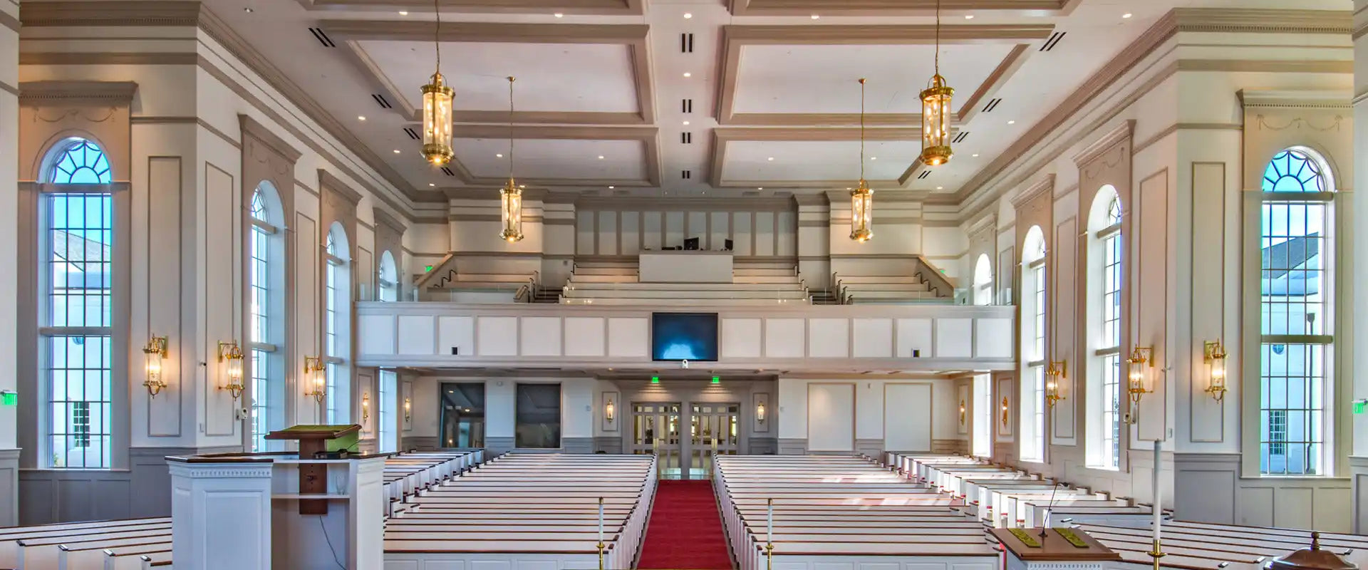 Spacious, well-lit church interior with rows of pews and a high ceiling.