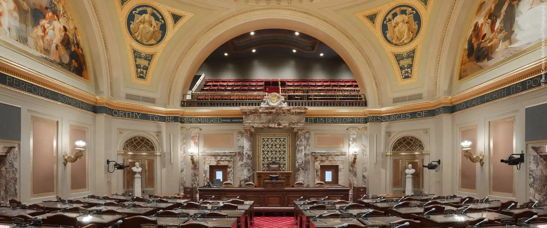 Ornate legislative chamber with tiered seating and a grand dais.