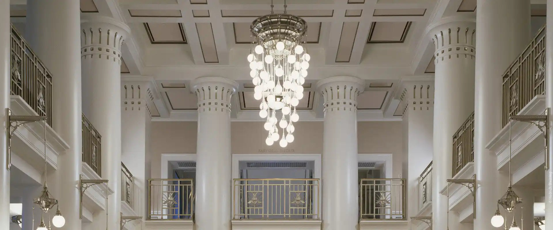 An elaborate multi-tiered chandelier with numerous glowing spherical bulbs.