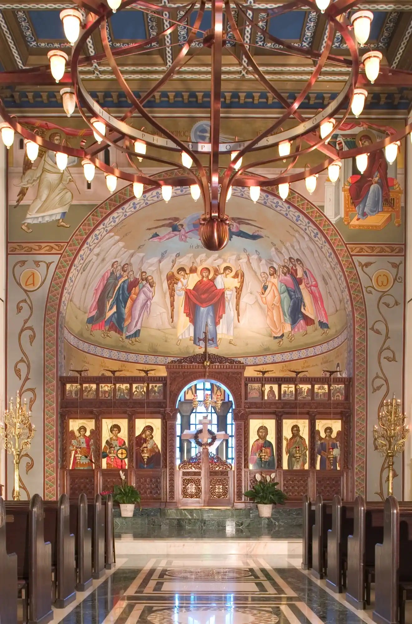 Ornate church interior with a grand chandelier and religious frescoes.