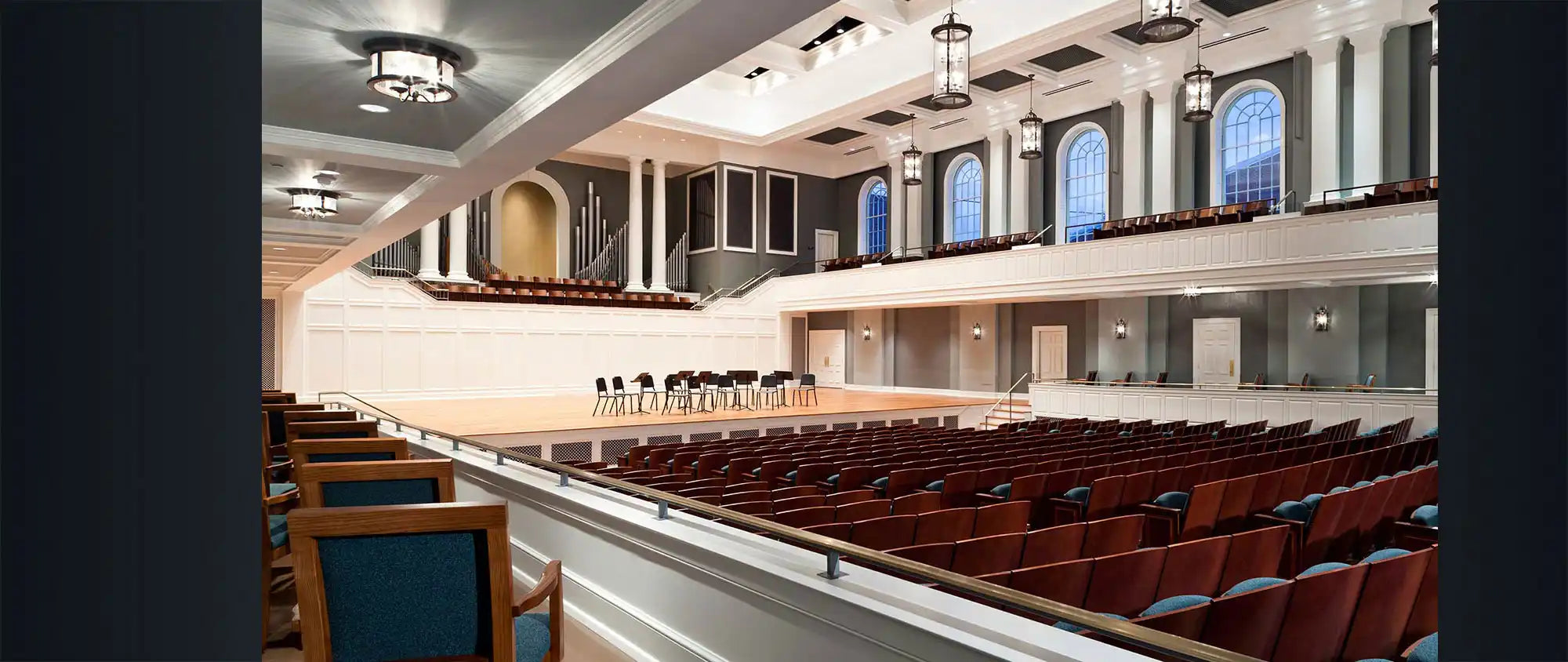 Spacious, elegant concert hall with rows of seating and a stage.